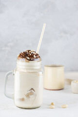 Milkshake with nuts and caramel in a mug on a light background. Vegan, sugar and lactose free.