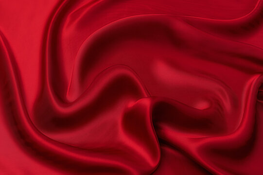 Close-up texture of natural red or pink fabric or cloth in same color. Fabric texture of natural cotton, silk or wool, or linen textile material. Red and orange canvas background.