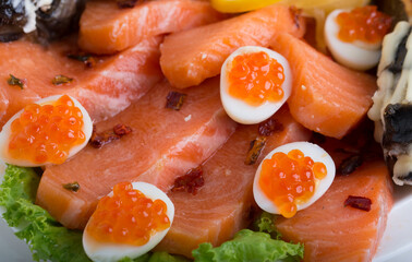 Seafood appetizers. Sandwiches with a game, a tartlet appetizer with sauce and red caviar, sliced red salmon fish and cream sauce with scrambled eggs.