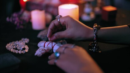Evil witch hands piercing voodoo doll with pins, dark magic, occult ritual