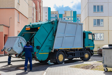 An automobile garbage truck collects garbage in residential areas of a modern city. Close-up of a...