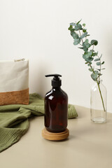 Pump amber glass bottle on wooden stand. Soap liquid, shampoo or shower gel packaging design.