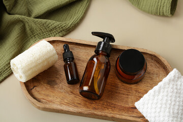 Set of amber glass bottles with natural cosmetics on wooden tray. SPA, bathroom beauty products...