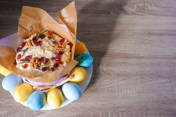 Easter composition. Decorated Easter sweet cake painted eggs on a plate. Place for text. Easter cake and painted eggs.