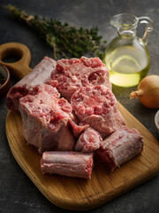 Fresh and raw oxtail cut on the cutting board on a grey background.