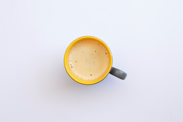 White coffee with milk in a mug view from top isolated over white background.