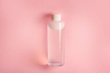 clean bottle of micellar water on pink background