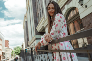 Pretty young woman posing on the building background. Stylish mixed race girl smiling and looking at camera