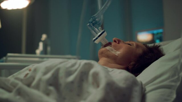 Patient breathing oxygen mask in hospital closeup. Terminally ill person clinic.