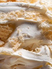 Frozen Creamy flavour gelato (called Russian Ice Cream) - full frame detail. Close up of a white surface texture of Ice cream covered with pieces of broken waffle.