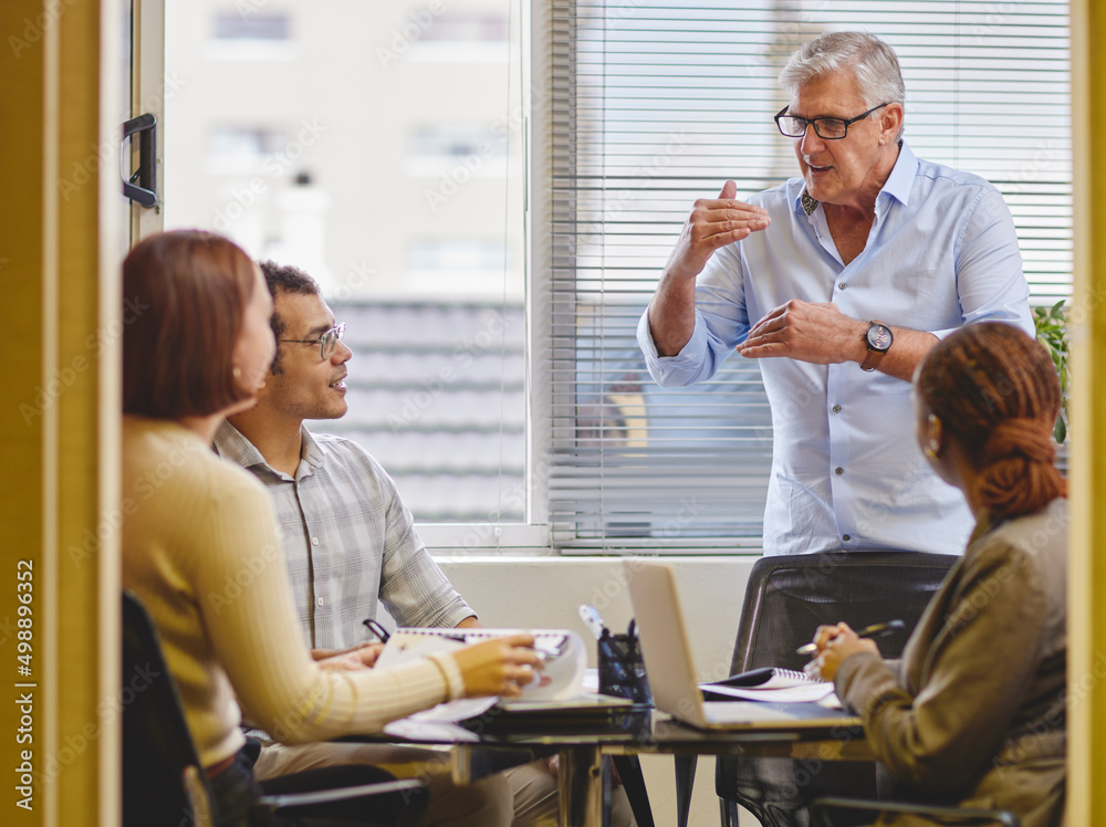 Poster let me explain. cropped shot of a handsome mature businessman explaining an idea to his colleagues i