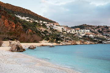 Fototapeta premium Kalkan,Antalya,Turkey beach,sunset in town,coastline.Beautiful turquoise calm sea, empty seaside.Breathtaking seaview at mountain,copy space
