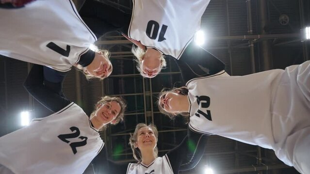 Group of basketball players shouts and high-five to each other, raising morale before the game, the international women's basketball championship, 4k slow motion.