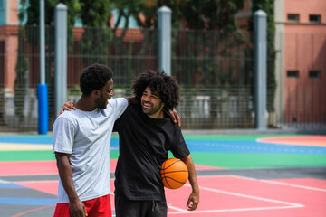Obraz premium two friends hug happily while playing basketball