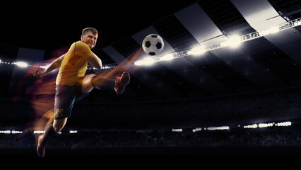 Fototapeta na wymiar Professional football or soccer player in action on stadium with flashlights, kicking ball for winning goal. Concept of sport, competition, motion, overcoming.
