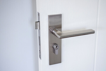 Modern door handle with on white door - obrazy, fototapety, plakaty