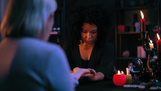 Distressed palm reader forecasting unhappy future to customer chiromancy session