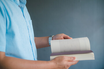 Business man reading a book on gray background.