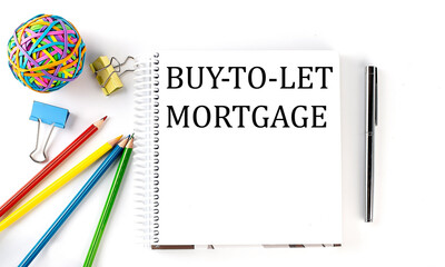Notebook ,pencils,pen and rubber band with text BUY-TO-LET MORTGAGE on the white background