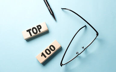 TOP 100 text on the wooden block ,blue background