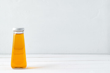 Small glass bottle of fresh juice on white background