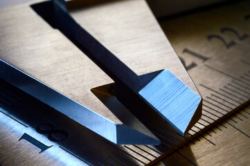 locksmith measuring tool lies on the background of metal rulers. close-up