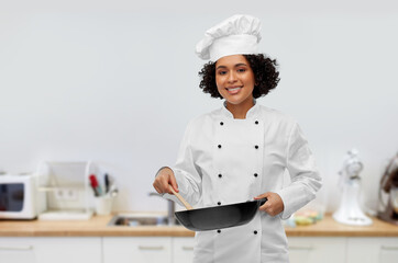 food cooking, culinary and people concept - happy smiling female chef with frying pan over kitchen...