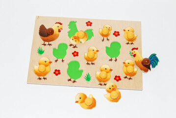 Wooden toy for baby, children isolated on white background. Mosaic with chickens, rooster and hen.
