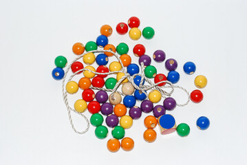 Wooden toy for baby, children isolated on white background. Wooden balls of different colors with a hole and a string.