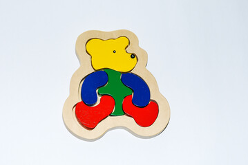 Wooden toy for baby, children isolated on white background. Mosaic with bear.
