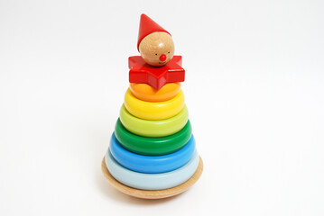Wooden toy for baby, children isolated on white background. Rings of different colors and sizes are stacked. People with hat.
