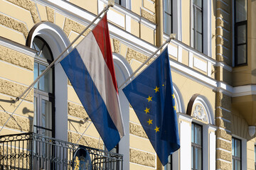 Flags of the European Union and the Netherlands hang on the facade of the embassy building