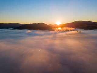 Sunrise over the fog in the Ukrainian Carpathians. Aerial drone view.