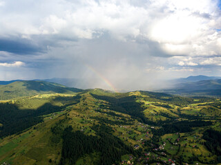 Obraz na płótnie Canvas Rainbow in the mountains of the Ukrainian Carpathians. Aerial drone view.