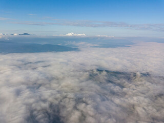 High flight above the clouds in the mountains. Aerial drone view.