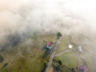 Mountain settlement in the Ukrainian Carpathians in the morning mist. Aerial drone view.