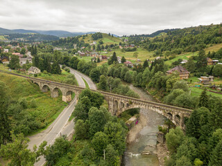 Old railway bridge in the mountains. Ukrainian Carpathians. Aerial drone view.