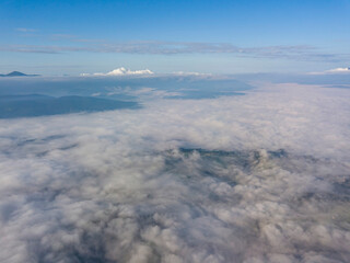 High flight above the clouds in the mountains. Aerial drone view.