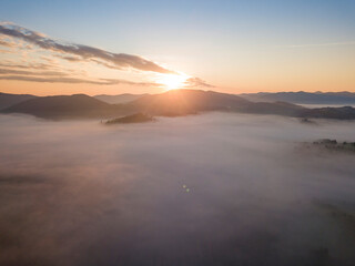 Fototapeta na wymiar Sunrise over the fog in the Ukrainian Carpathians. Aerial drone view.