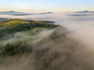 Fototapeta na wymiar The rays of dawn over the fog in the Ukrainian Carpathians. Aerial drone view.