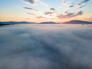 Sunrise over the fog in the Ukrainian Carpathians. Aerial drone view.