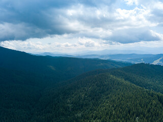 Green mountains of Ukrainian Carpathians in summer. Sunny day, rare clouds. Aerial drone view.