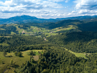 Obraz premium Green mountains of Ukrainian Carpathians in summer. Coniferous trees on the slopes. Aerial drone view.
