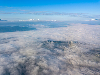 High flight above the clouds in the mountains. Aerial drone view.