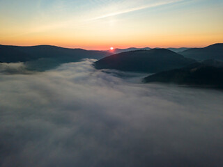 Sunrise over the fog in the Ukrainian Carpathians. Aerial drone view.
