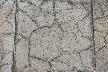 Grey paving slabs with a stone texture and scuffs. Grey vintage background. Street surface.
