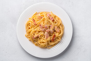 Classic pasta carbonara with bacon, cheese, egg and pepper on a gray background. Italian food.