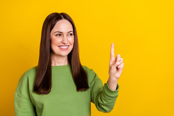 Portrait of attractive cheerful woman touching press device copy space isolated over bright yellow...