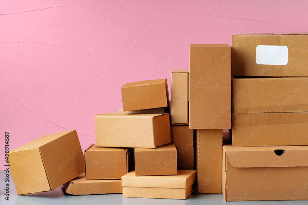 Wall mural Set of cardboard boxes on pink background