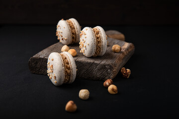 Macarons mit Heselnuss, schwarze Hintergrund, drei Stück.
